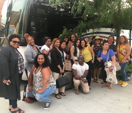 A group of caregivers standing in front of a bus
